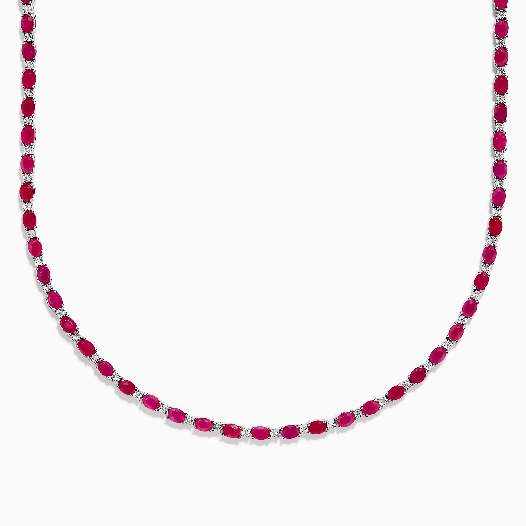 The 925 Sterling Silver Ruby and Diamond Tennis Necklace showcases a continuous row of oval red gemstones in silver prong settings, elegantly displayed against a white background.