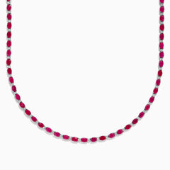 The 925 Sterling Silver Ruby and Diamond Tennis Necklace showcases a continuous row of oval red gemstones in silver prong settings, elegantly displayed against a white background.