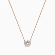 The Novelty 14K Rose Gold Diamond Crown Necklace features a delicate chain and crown-shaped pendant adorned with small sparkling stones, a heart motif at the center, and a single larger stone at the top.
