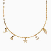 The Seaside 14K Yellow Gold Diamond Charm Necklace by Effy features five nautical charms—dolphin, sailboat, starfish, anchor, and seahorse—with some accented by sparkling diamonds for added shimmer.