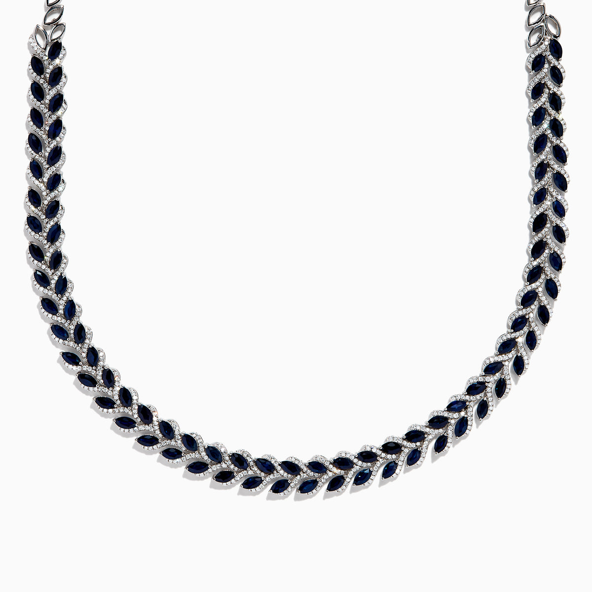 The 14K White Gold Blue Sapphire and Diamond Leaf Motif Necklace showcases a graceful, leaf-inspired design with alternating rows of blue sapphires and diamond accents for a sparkling, elegant look.