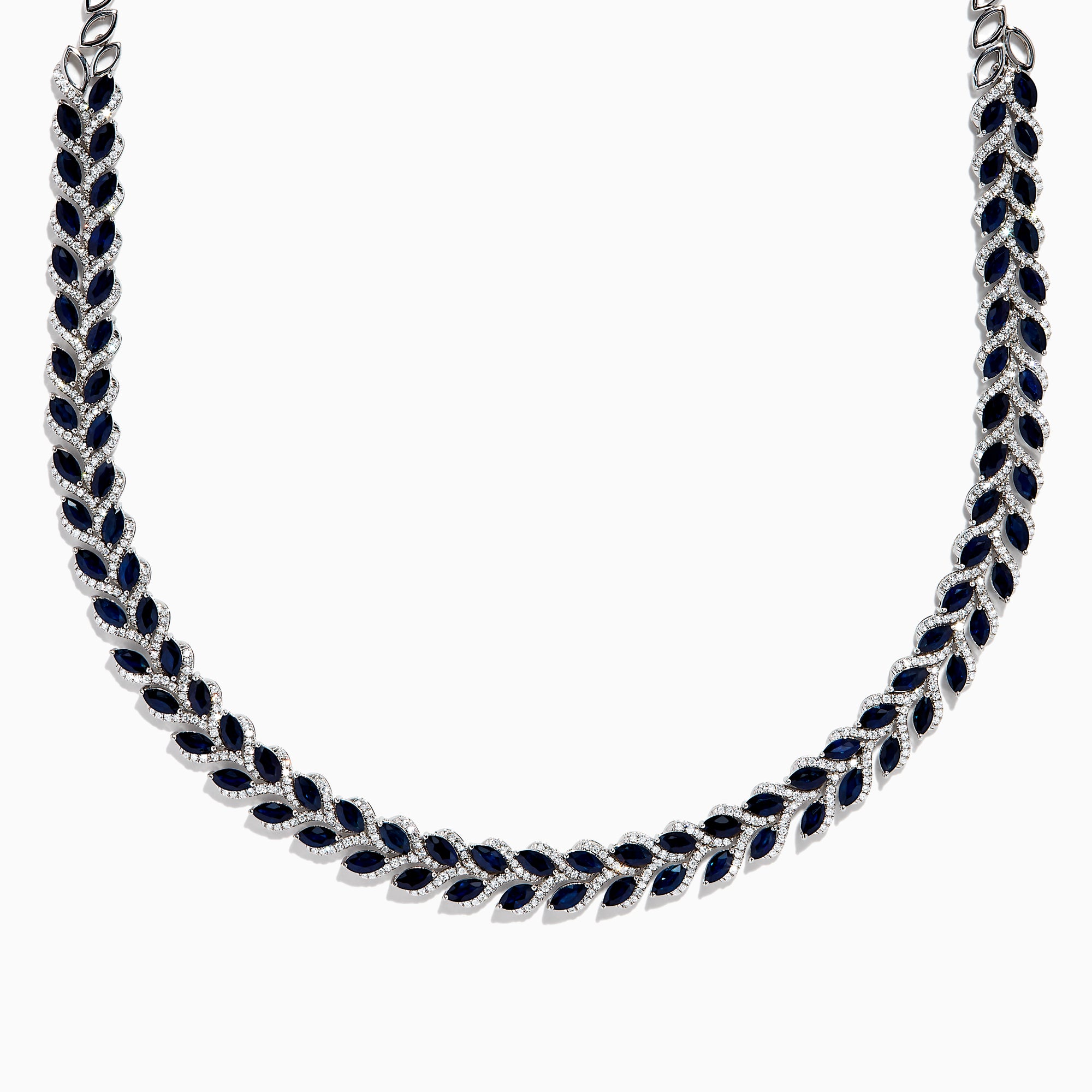 The 14K White Gold Blue Sapphire and Diamond Leaf Motif Necklace showcases a graceful, leaf-inspired design with alternating rows of blue sapphires and diamond accents for a sparkling, elegant look.