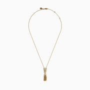 The Web Exclusive 14K Yellow Gold Diamond and Emerald Lariat Tassel Panther Pendant features a diamond-encrusted panther head with emerald eyes, holding a sparkling ring and gold beaded tassels below.