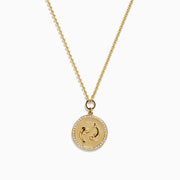 The Zodiac 14K Yellow Gold and Diamond Pisces Necklace features a circular pendant with two embossed dolphins symbolizing Pisces, surrounded by sparkling diamonds for added elegance.