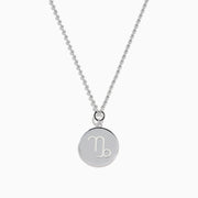 The Zodiac 925 Sterling Silver and Diamond Capricorn Necklace features a round, textured pendant engraved with a figure playing soccer, offering a unique twist on the classic Zodiac style. Shown against a plain white background.
