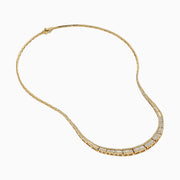 The 14K Yellow Gold Diamond Graduating Collar Necklace features a stunning curved design with alternating rectangular diamond segments and polished gold, showcased elegantly on a white background.