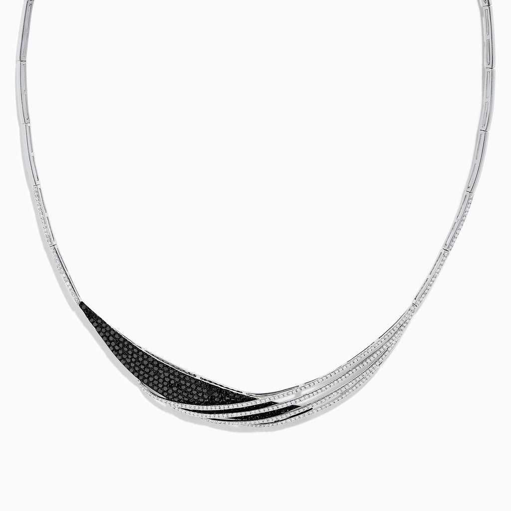 The 14K White Gold Black and White Diamond Necklace features an asymmetrical, sweeping design with textured sections set with small black diamonds.