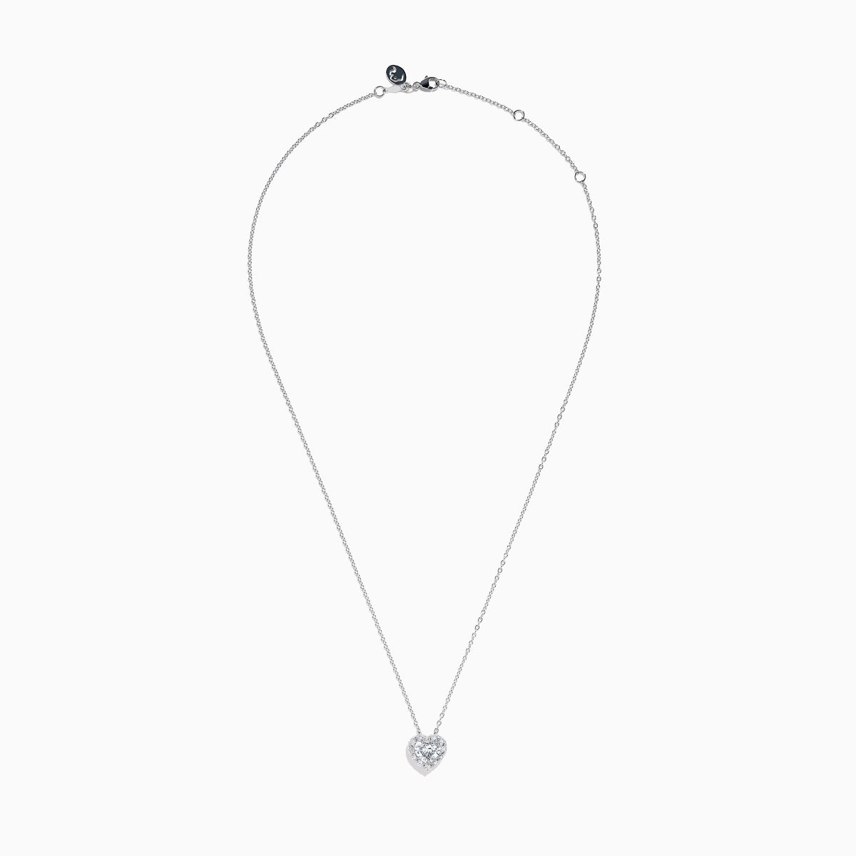 The Lab Grown Heart and Round Diamond Halo Pendant in 14K White Gold features a sparkling heart-shaped lab grown diamond with a halo of smaller diamonds on a delicate silver chain, shown against a plain white background.