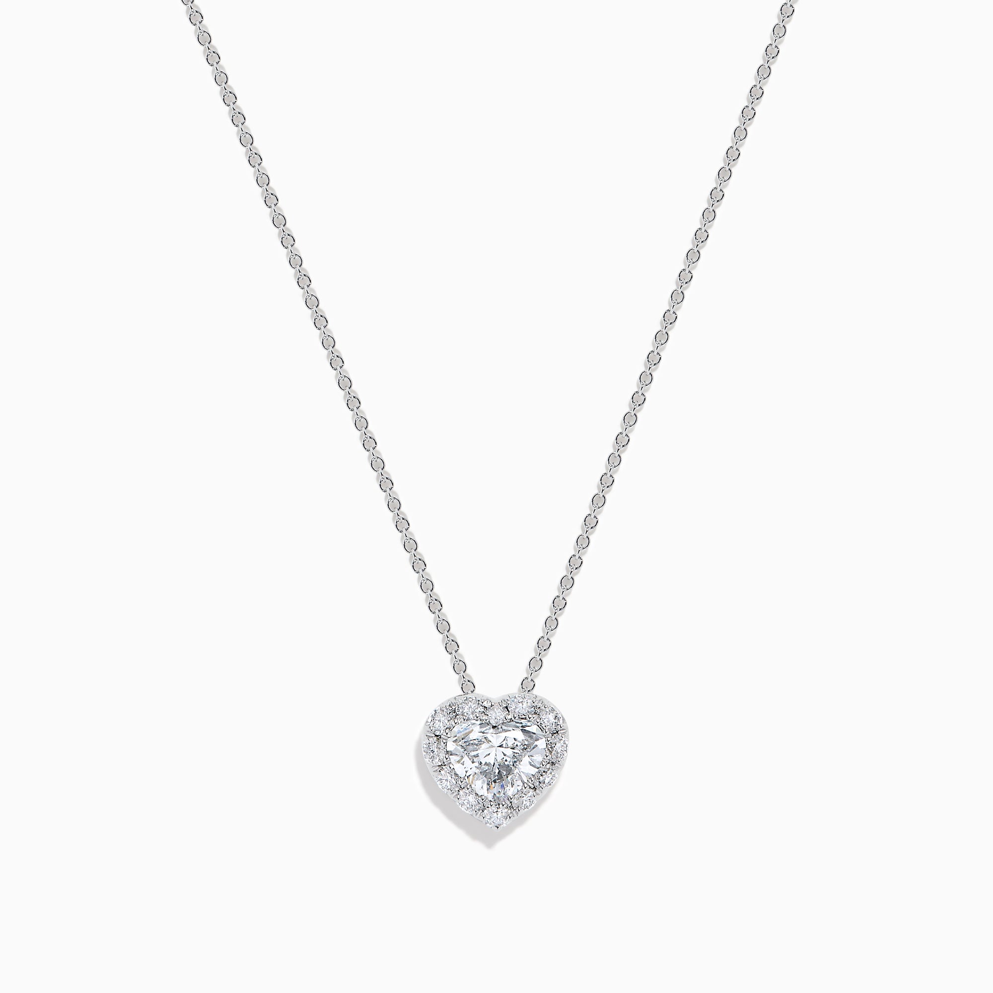 The Lab Grown Heart and Round Diamond Halo Pendant in 14K White Gold features a sparkling heart-shaped lab grown diamond with a halo of smaller diamonds on a delicate silver chain, shown against a plain white background.