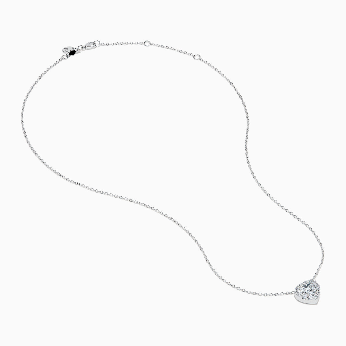 The Lab Grown Heart and Round Diamond Halo Pendant in 14K White Gold features a sparkling heart-shaped lab grown diamond with a halo of smaller diamonds on a delicate silver chain, shown against a plain white background.