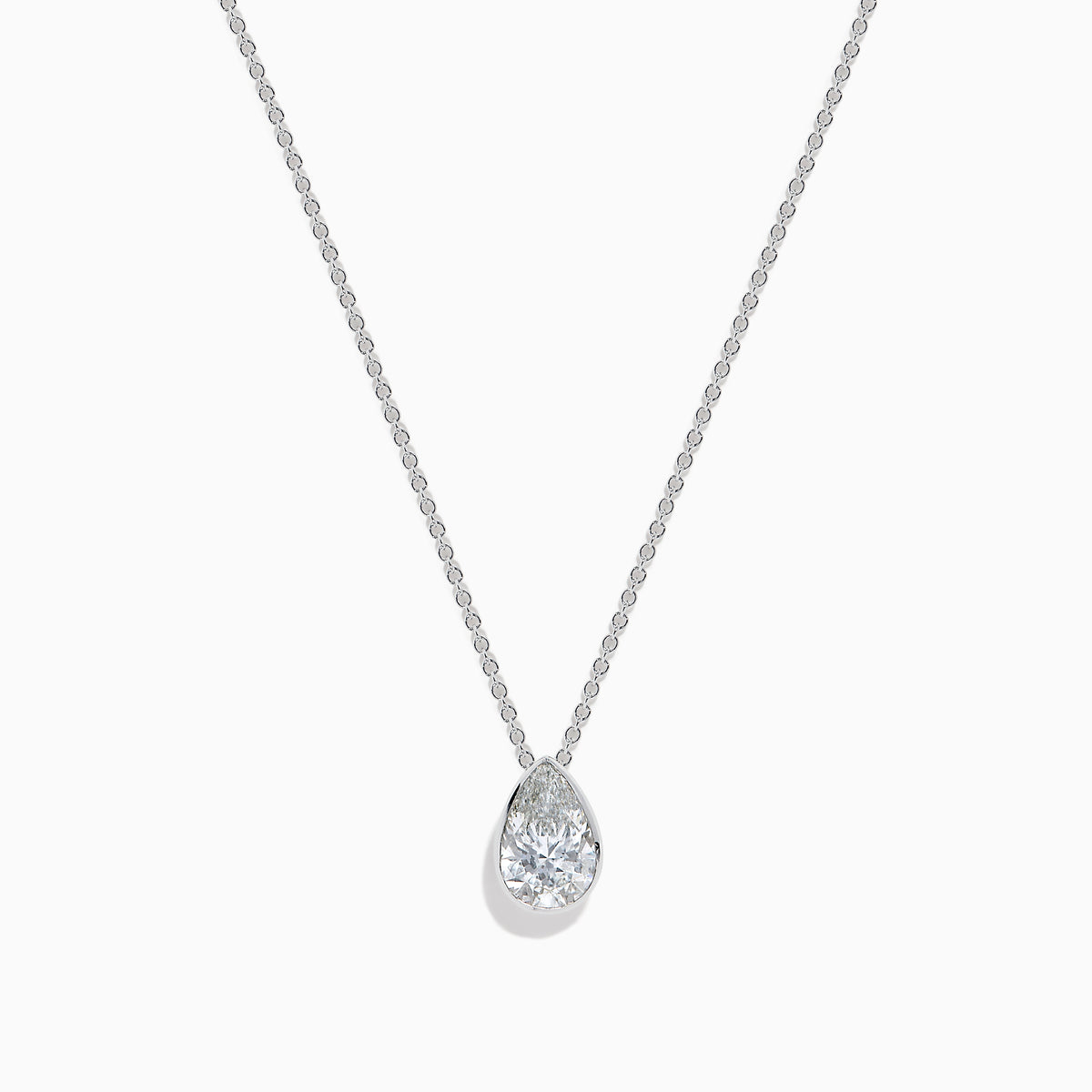 The Lab Grown Pear Diamond Bezel Pendant in 14K White Gold features a delicate silver chain and a pear-shaped lab grown diamond in an elegant bezel setting, showcased against a white background.