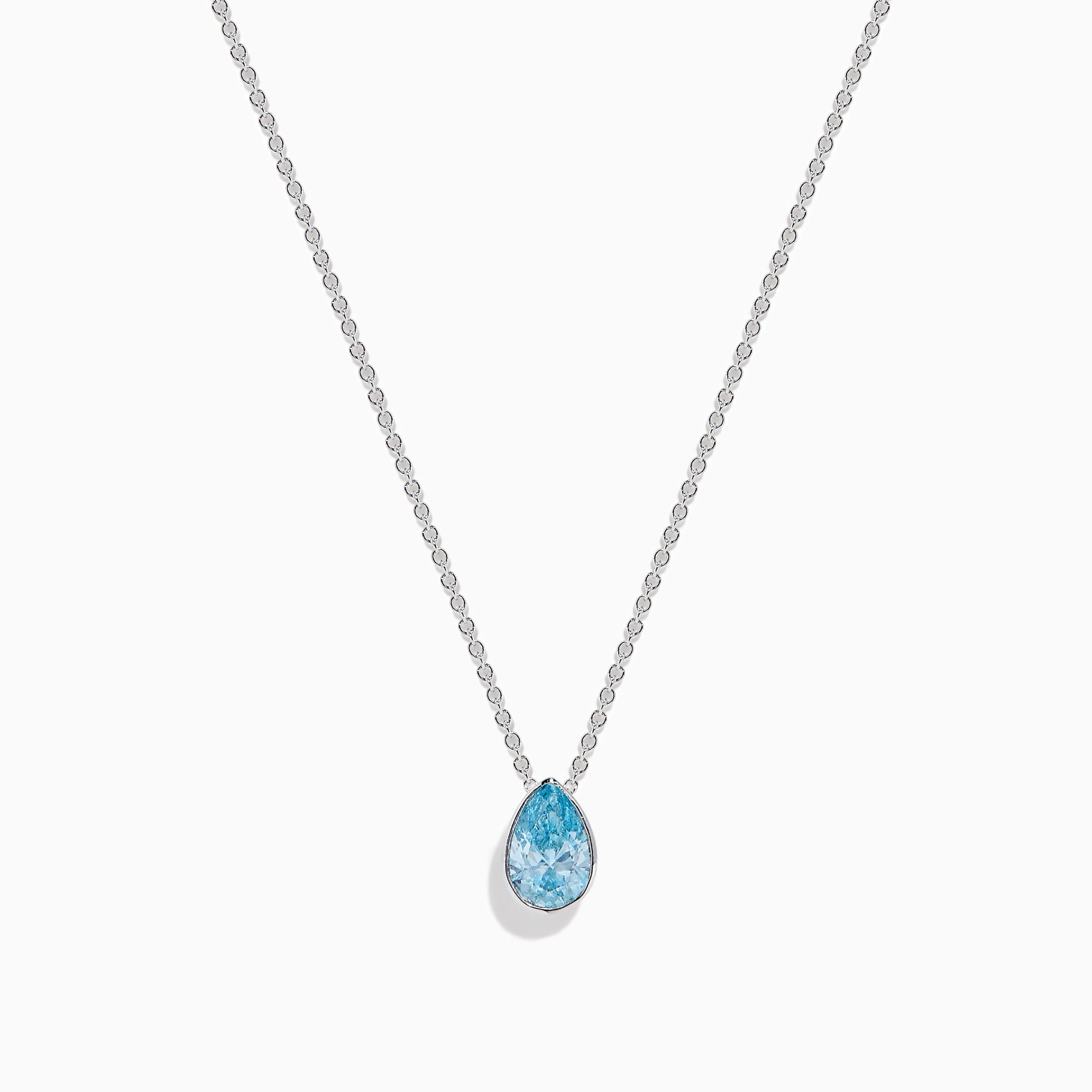 The Lab Grown Pear Solitaire Blue Diamond Collarbone Necklace in 14K White Gold features a minimalist bezel-set, teardrop-shaped blue diamond pendant on a fine white gold chain, elegantly displayed against a white background.