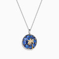 The Nahla 925 Sterling Silver and 14K Yellow Gold Tanzanite & Diamond Palm Tree Pendant features tanzanite gemstones, sparkling diamonds, and a gold palm tree design on a round pendant.