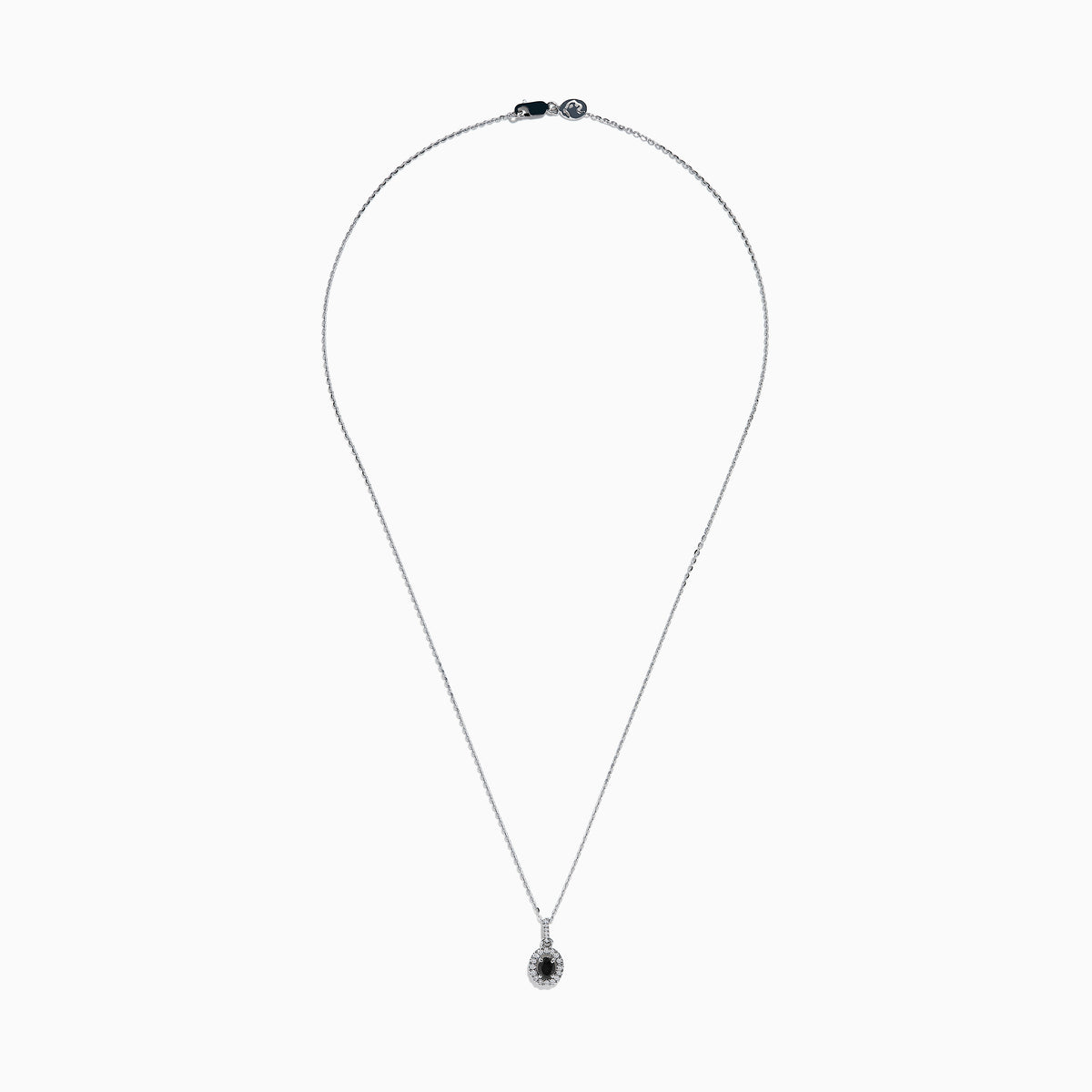The 14K White Gold Black and White Diamond Halo Pendant showcases an oval black gemstone encircled by sparkling white diamonds, creating a striking contrast against a white background.