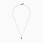 The 14K White Gold Black and White Diamond Halo Pendant features a central black diamond encircled by a halo of white diamonds, shown against a plain white background.