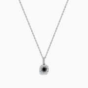 The 14K White Gold Black and White Diamond Halo Pendant features a central black diamond encircled by a halo of white diamonds, shown against a plain white background.