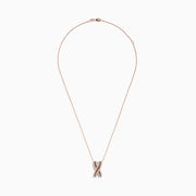 The 14K Rose Gold Brown and White Diamond Pendant features an “X”-shaped design with intertwined rows of brown and white diamonds, suspended from a delicate chain.