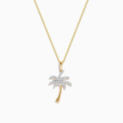 The 14K Yellow Gold Diamond Palm Tree Pendant features a delicate chain and sparkling white stones, combining gold and silver tones for an elegant, eye-catching look.