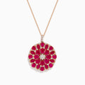 The Ruby Royale 14K Rose Gold Ruby and Diamond Flower Pendant features a round floral design with rubies and diamond accents at the center and edges.