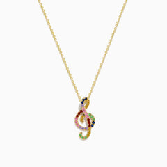 The Novelty 14K Yellow Gold Multi Sapphire Tsavorite Treble Clef Pendant is showcased on a plain white background.