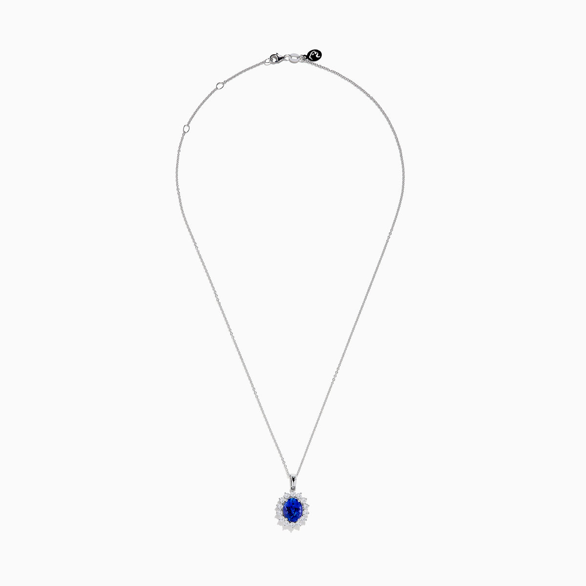 The Nahla Siri 14K White Gold Tanzanite and Diamond Pendant features an oval tanzanite stone encircled by a halo of sparkling diamonds, showcased on a white background.