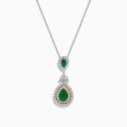 The 14K Two Tone Gold Emerald and Diamond Double Pear Drop Pendant features two pear-shaped emeralds, each encircled by white diamonds and linked with a cluster of diamonds.