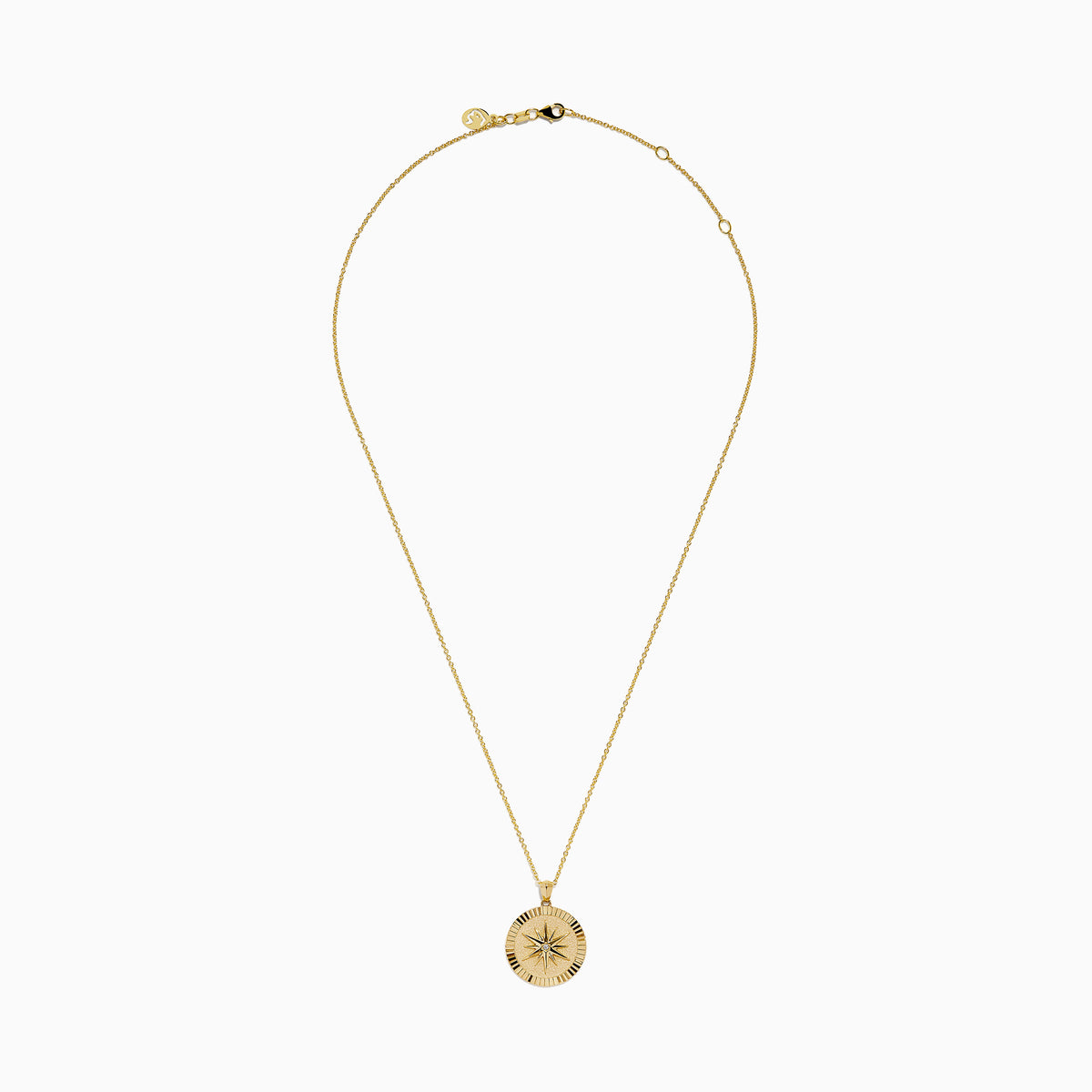 The D'Oro 14K Yellow Gold Diamond Compass Coin Pendant features a round medallion with a compass-inspired design, accented by a diamond at the center and suspended from a delicate yellow gold chain.
