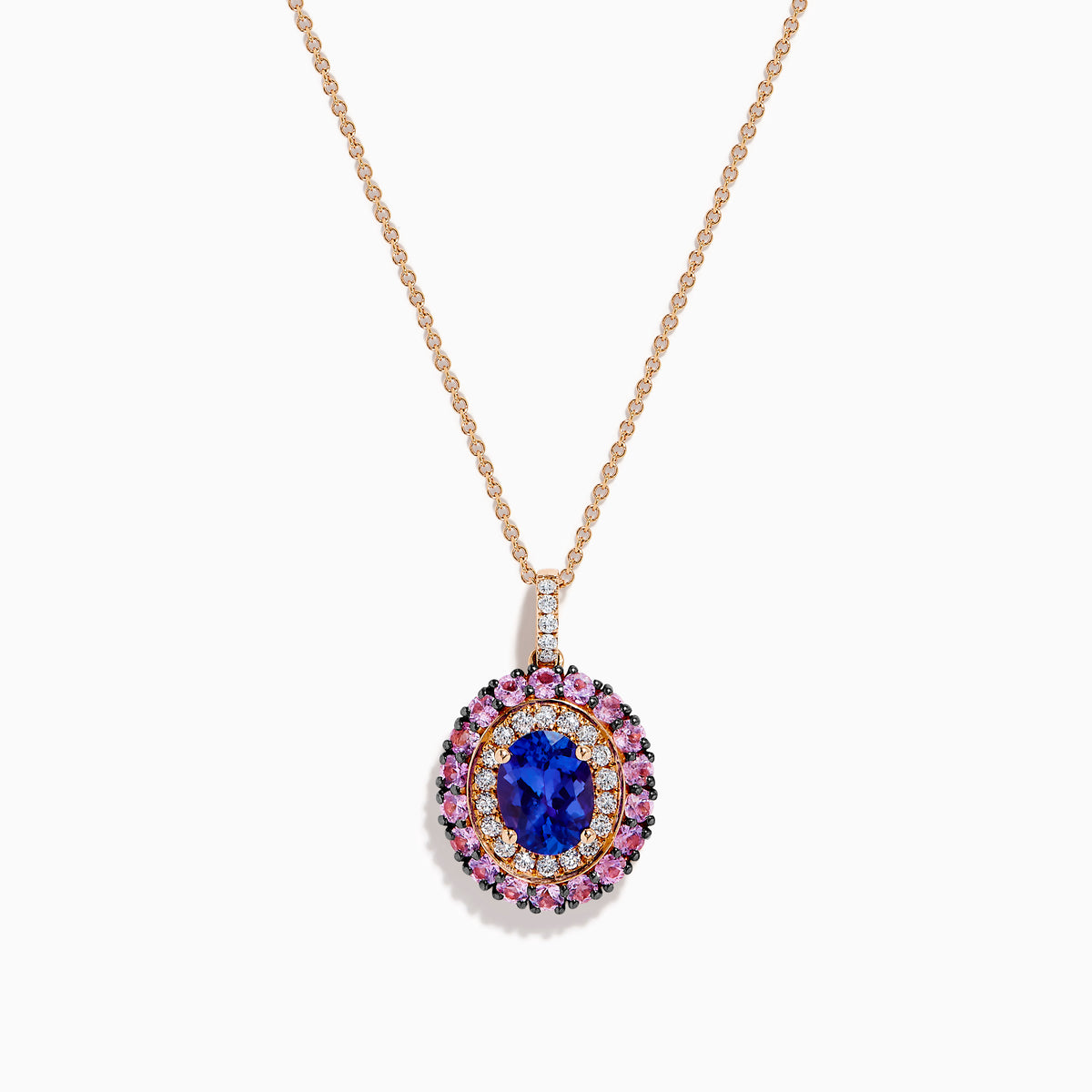 The 14K Rose Gold Pink Sapphire, Tanzanite, and Diamond Double Halo Pendant features an oval-shaped blue gemstone surrounded by pink sapphires, tanzanite, and diamonds on a delicate 14K rose gold chain attached at the top.