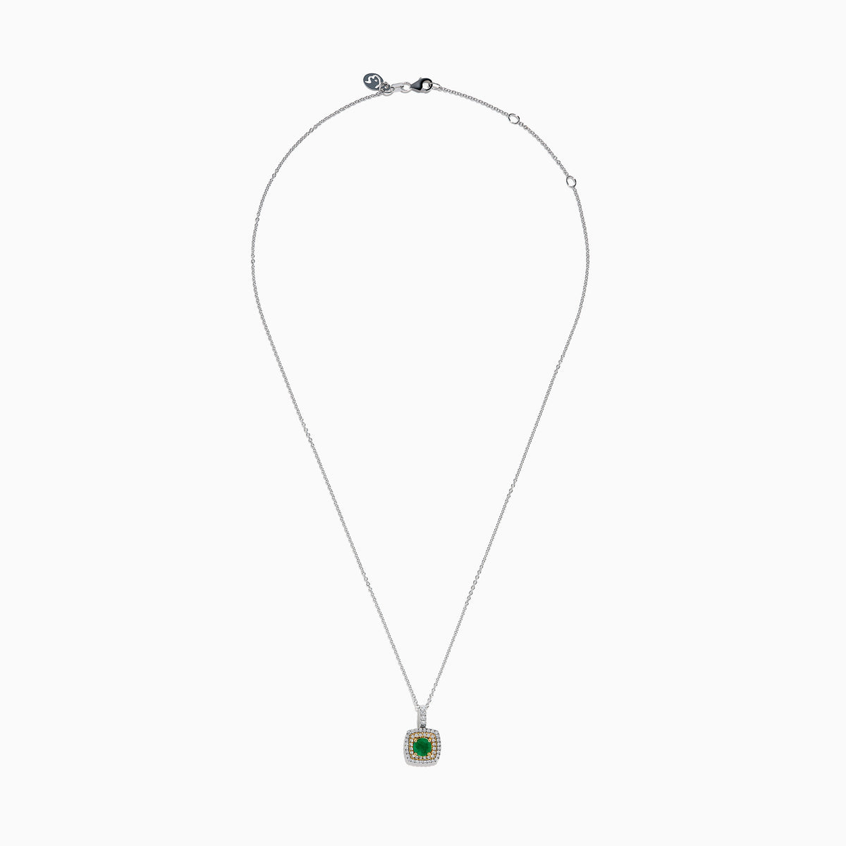 The 14K Two Tone Gold Emerald and Diamond Double Halo Pendant features a central green emerald surrounded by two rows of sparkling diamonds, all suspended from a delicate chain, showcased on a white background.