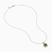 The 14K Two Tone Gold Emerald and Diamond Double Halo Pendant features a central green emerald surrounded by two rows of sparkling diamonds, all suspended from a delicate chain, showcased on a white background.