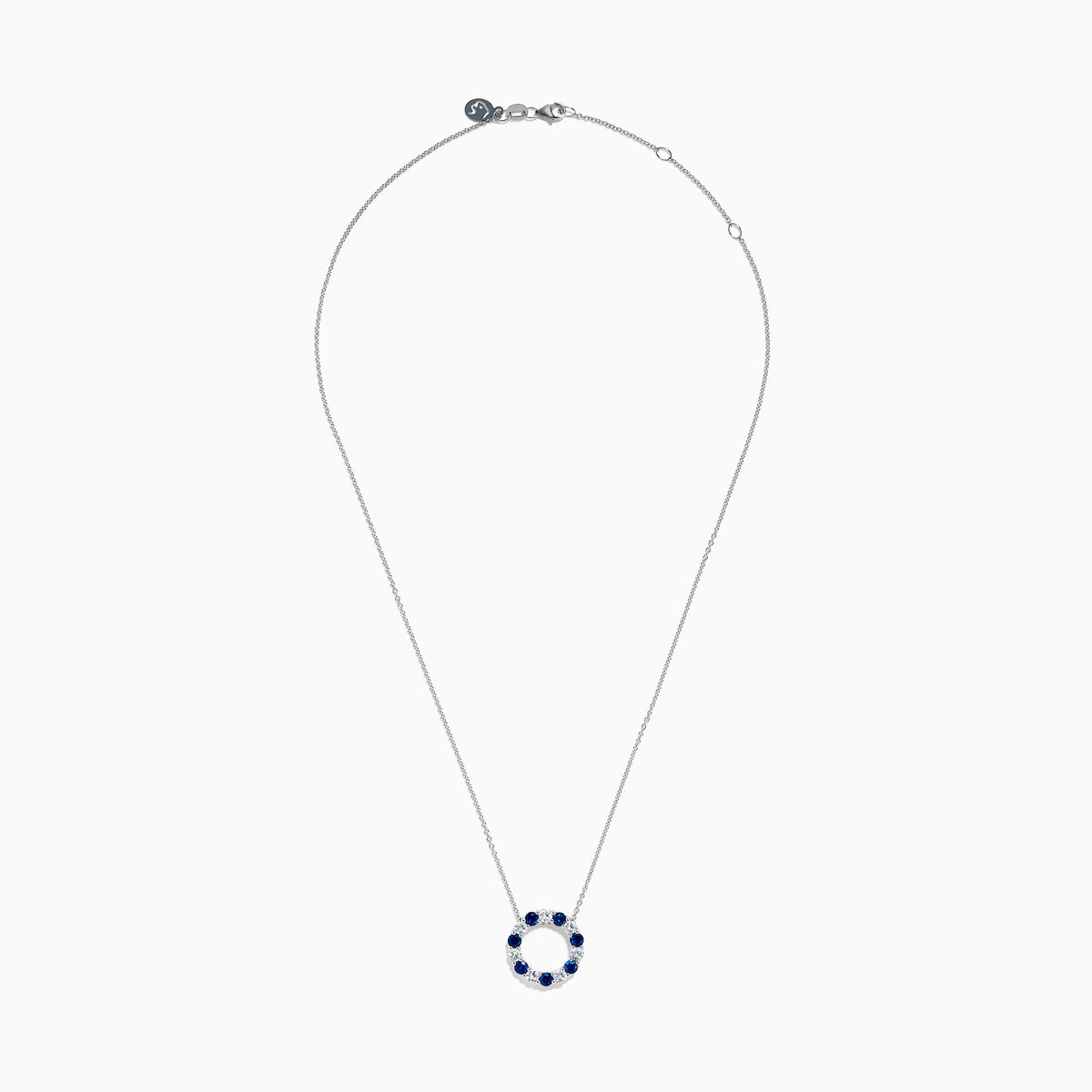 The Royale Bleu 14K white gold necklace features a circular eternity pendant with alternating blue and white sapphires, shown on a white background.