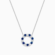 The Royale Bleu 14K white gold necklace features a circular eternity pendant with alternating blue and white sapphires, shown on a white background.
