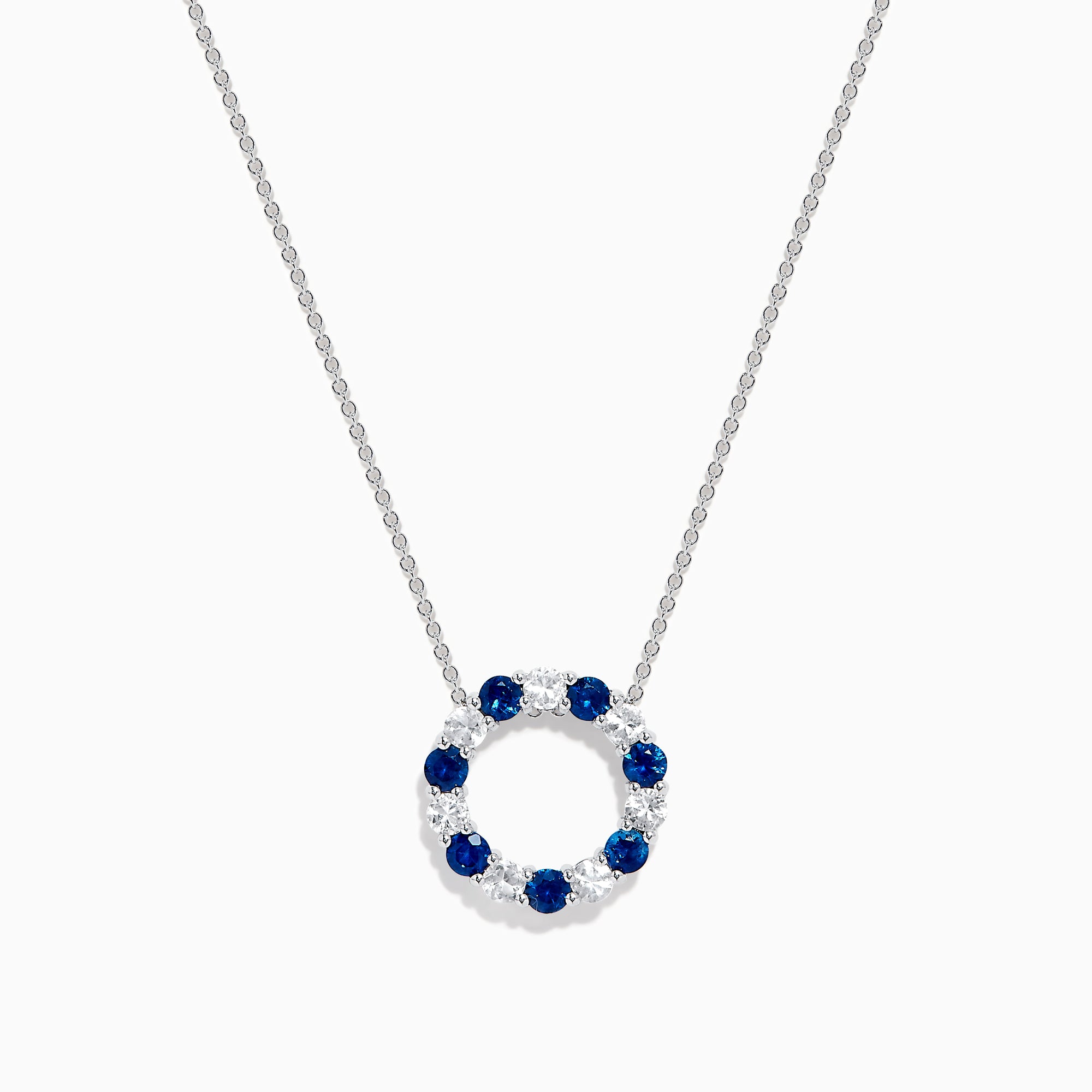 The Royale Bleu 14K white gold necklace features a circular eternity pendant with alternating blue and white sapphires, shown on a white background.