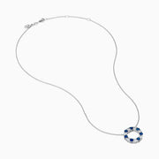 The Royale Bleu 14K white gold necklace features a circular eternity pendant with alternating blue and white sapphires, shown on a white background.