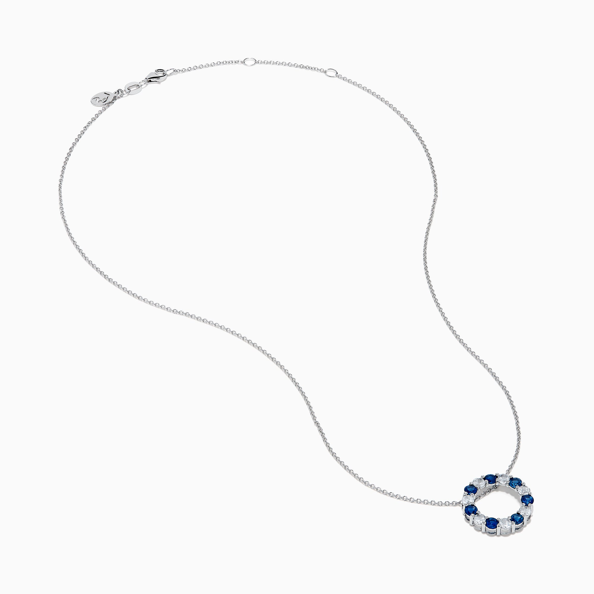 The Royale Bleu 14K white gold necklace features a circular eternity pendant with alternating blue and white sapphires, shown on a white background.