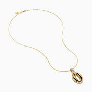 The 14K Yellow Gold Sculptural Oval Drop Pendant with Diamond Accents features an elegant oval design on a delicate chain, showcasing diamonds set in white metal at the top against a white background.