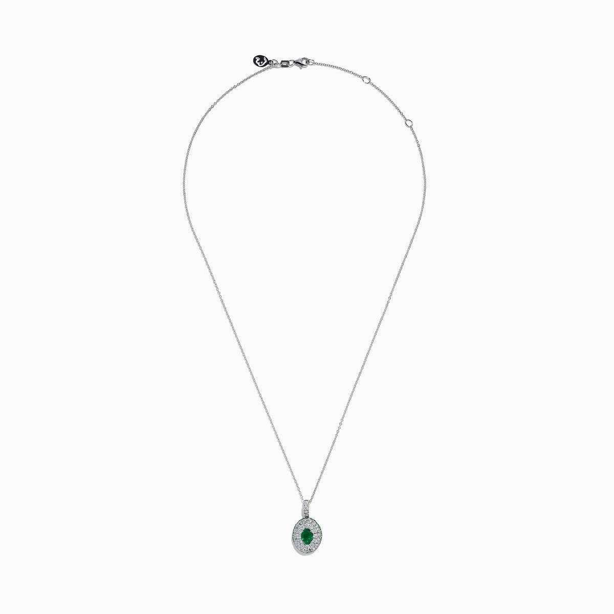 The 14K White Gold Emerald and White Sapphire Halo Pendant features an oval emerald accented by a double halo of sparkling white sapphires.