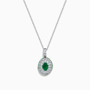 The 14K White Gold Emerald and White Sapphire Halo Pendant features an oval emerald accented by a double halo of sparkling white sapphires.
