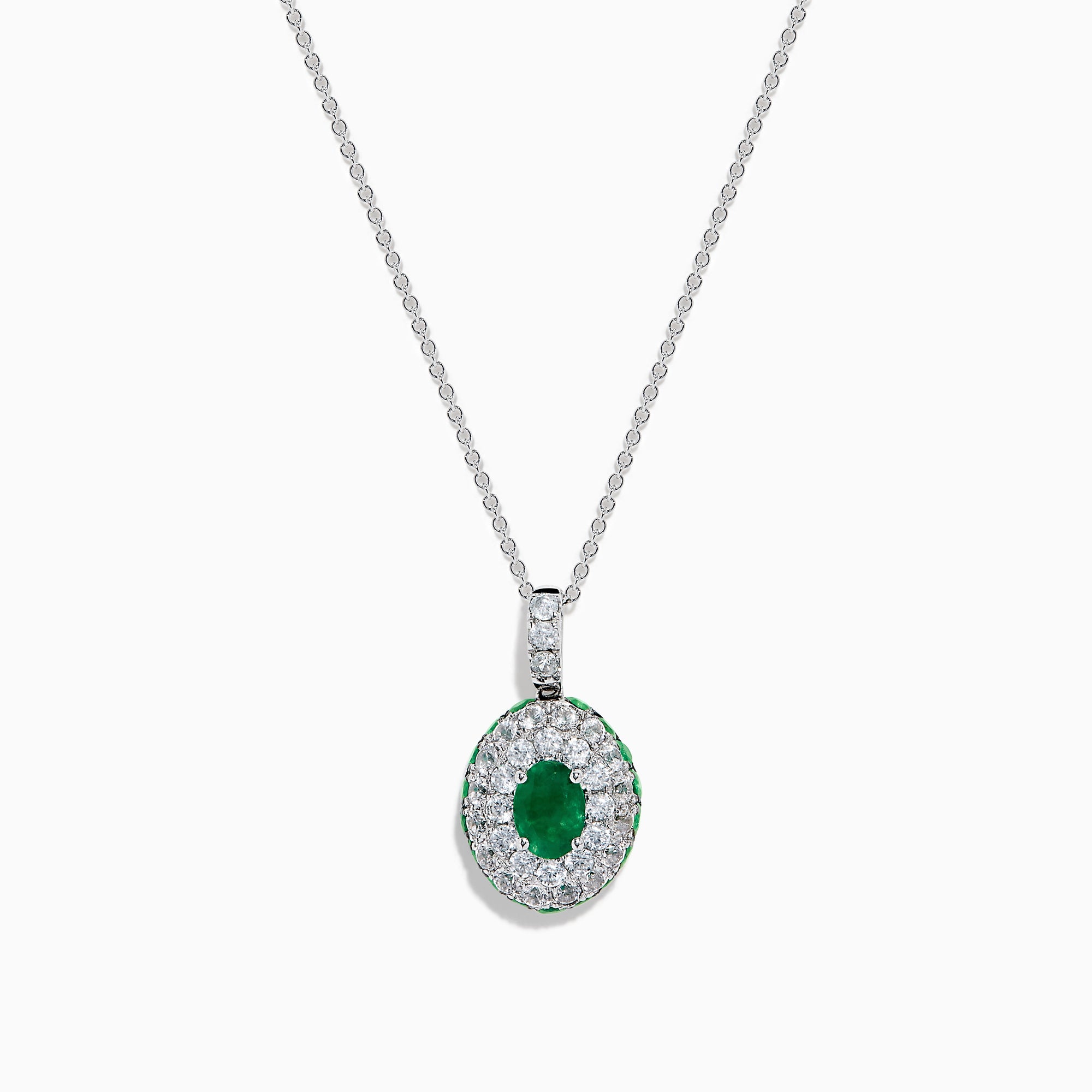 The 14K White Gold Emerald and White Sapphire Halo Pendant features an oval emerald accented by a double halo of sparkling white sapphires.