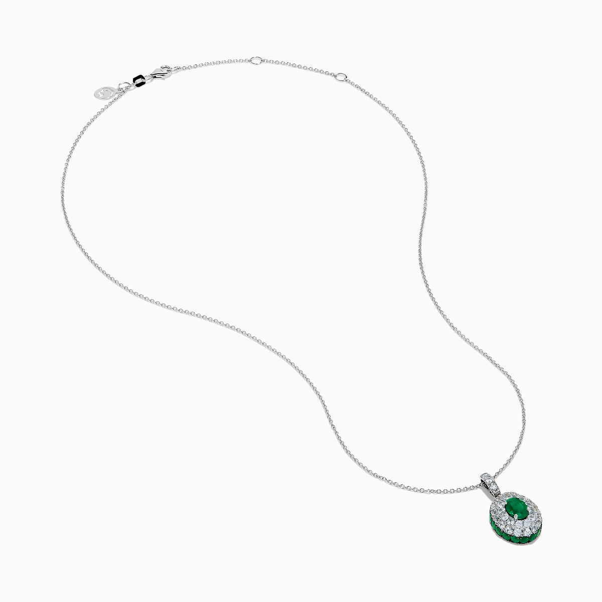 The 14K White Gold Emerald and White Sapphire Halo Pendant features an oval emerald accented by a double halo of sparkling white sapphires.
