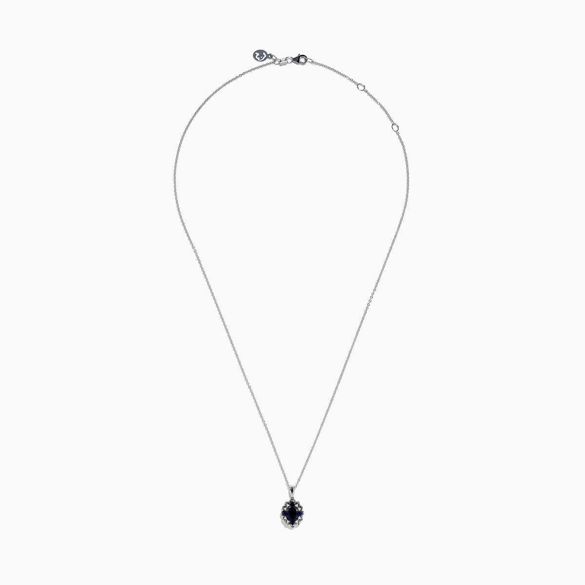 A 14K white gold Sapphire and Diamond Vintage Halo Pendant, featuring a large oval blue sapphire surrounded by smaller diamonds in a floral pattern, is displayed on a white background.