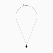 A 14K white gold Sapphire and Diamond Vintage Halo Pendant, featuring a large oval blue sapphire surrounded by smaller diamonds in a floral pattern, is displayed on a white background.