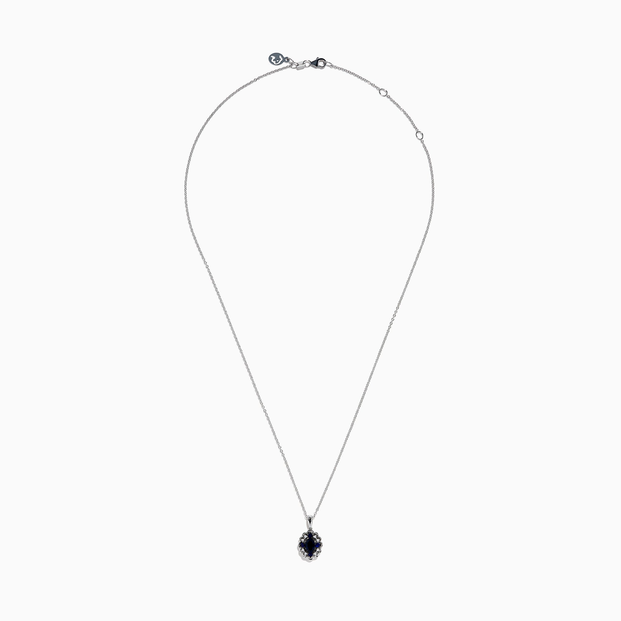 A 14K white gold Sapphire and Diamond Vintage Halo Pendant, featuring a large oval blue sapphire surrounded by smaller diamonds in a floral pattern, is displayed on a white background.