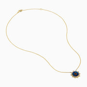 14K Yellow Gold Ruby, Diamond, and Enamel Pendant featuring a delicate gold chain, round pendant with blue and green enamel, a central ruby teardrop, and a sunburst of small clear stones.