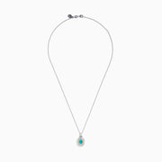 The 18K Two Tone Gold Paraiba and Diamond Double Halo Pendant showcases an oval Paraiba centerpiece, surrounded by a halo of yellow stones and a second halo of sparkling diamonds.