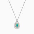 The 18K Two Tone Gold Paraiba and Diamond Double Halo Pendant showcases an oval Paraiba centerpiece, surrounded by a halo of yellow stones and a second halo of sparkling diamonds.