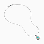 The 18K Two Tone Gold Paraiba and Diamond Double Halo Pendant showcases an oval Paraiba centerpiece, surrounded by a halo of yellow stones and a second halo of sparkling diamonds.