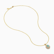 The 18K Yellow Gold Paraiba and Diamond Pendant features an oval turquoise Paraiba gemstone accented by a halo of sparkling diamonds, showcased against a white background.
