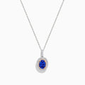 The Nahla Siri 14K White & Rose Gold Tanzanite and Diamond Pendant features an oval tanzanite surrounded by a double halo of diamonds, all set on a delicate silver chain and photographed against a white background.