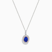 The Nahla Siri 14K White & Rose Gold Tanzanite and Diamond Pendant features an oval tanzanite surrounded by a double halo of diamonds, all set on a delicate silver chain and photographed against a white background.
